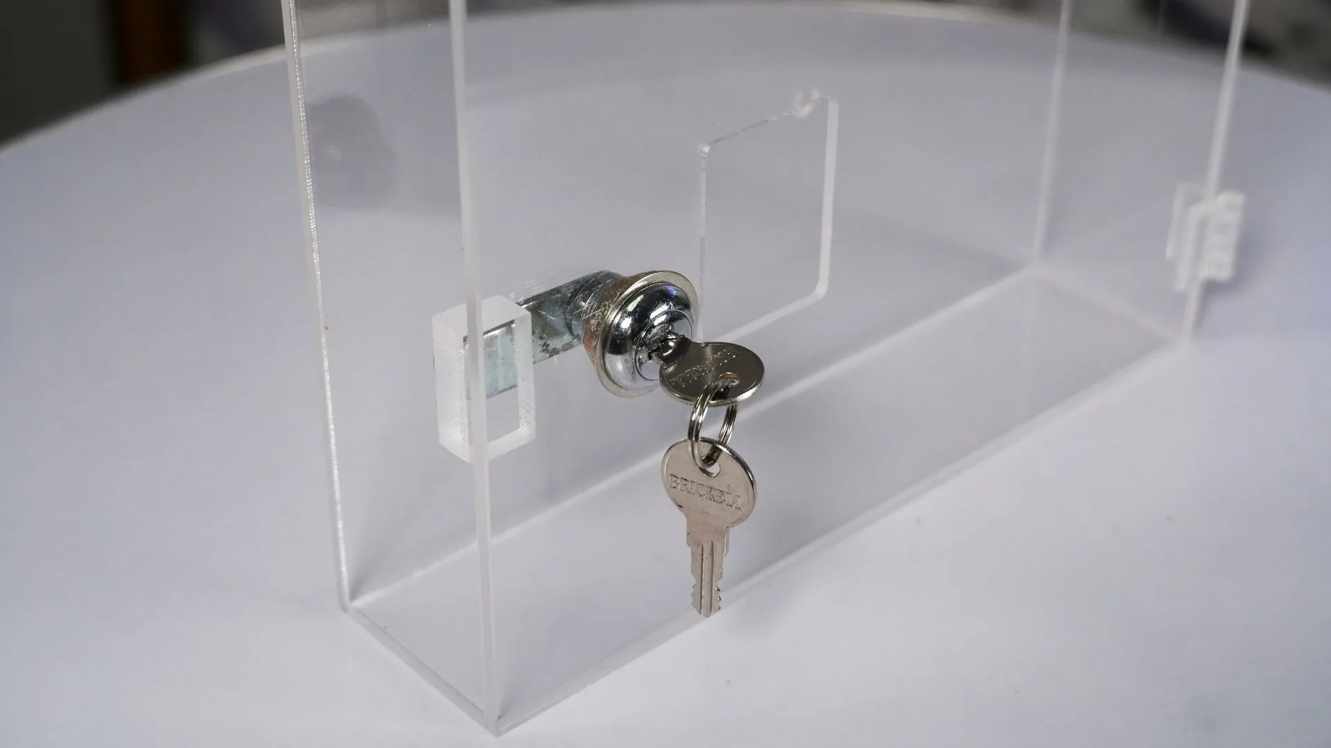 Caja acrílica de seguridad 7 Caja acrílica para reloj biométrico abierta, con la cerradura y las llaves a la vista.