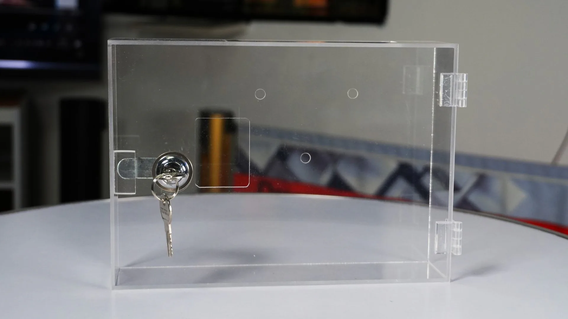 Caja acrílica de seguridad 10 Caja acrílica para reloj biométrico cerrada, con la llave puesta en la cerradura.