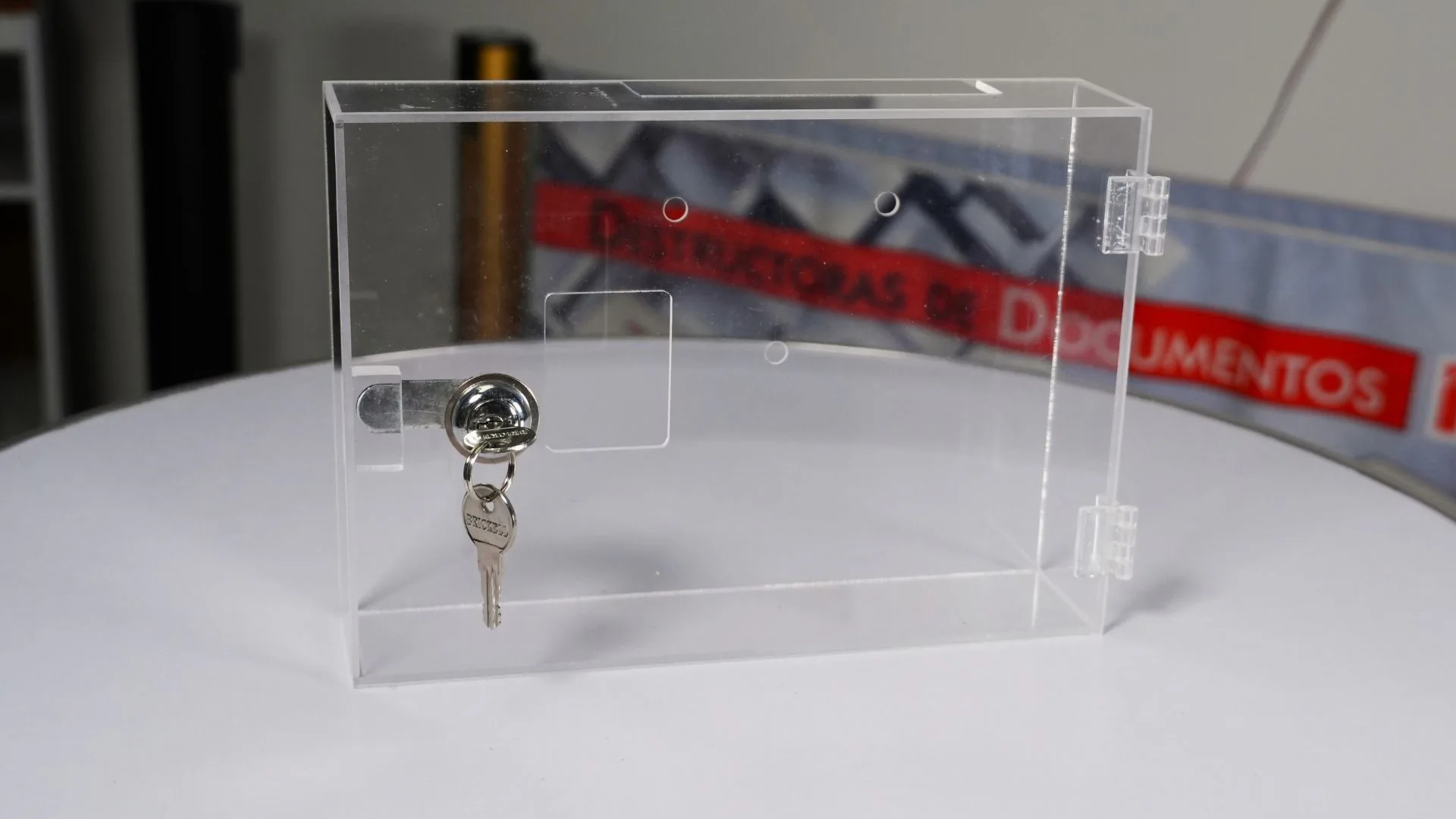 Caja acrílica para reloj biométrico de frente, con la cerradura y su ventana recortada.