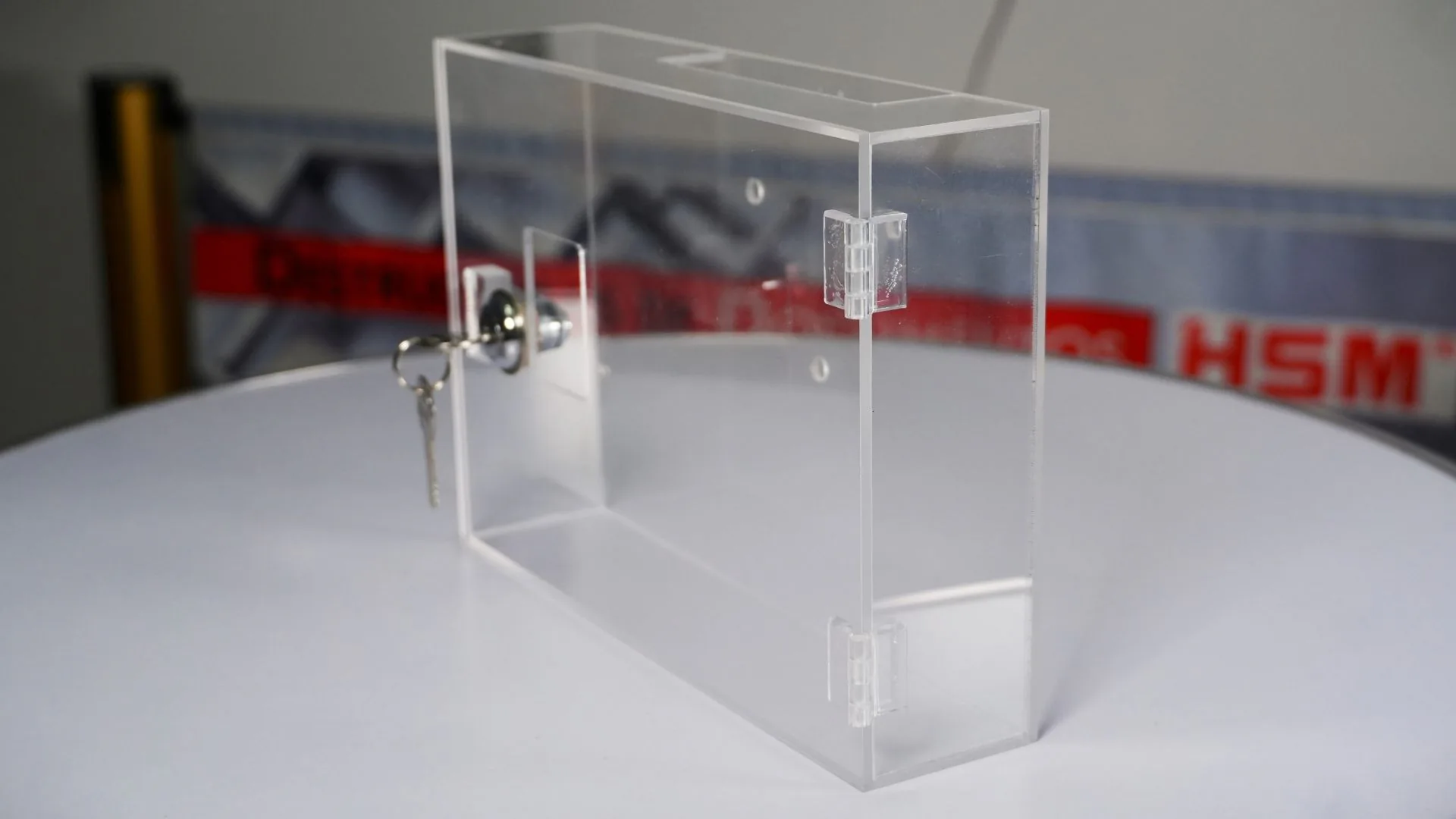 Caja acrílica de seguridad 6 Caja acrílica para reloj biométrico en vista de tres cuartos, cerrada con llave.