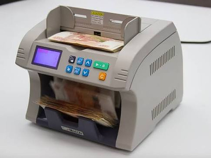 Contadora de billetes BILLCON N-120A sobre un mostrador con billetes en la tolva de entrada y en la bandeja de salida.