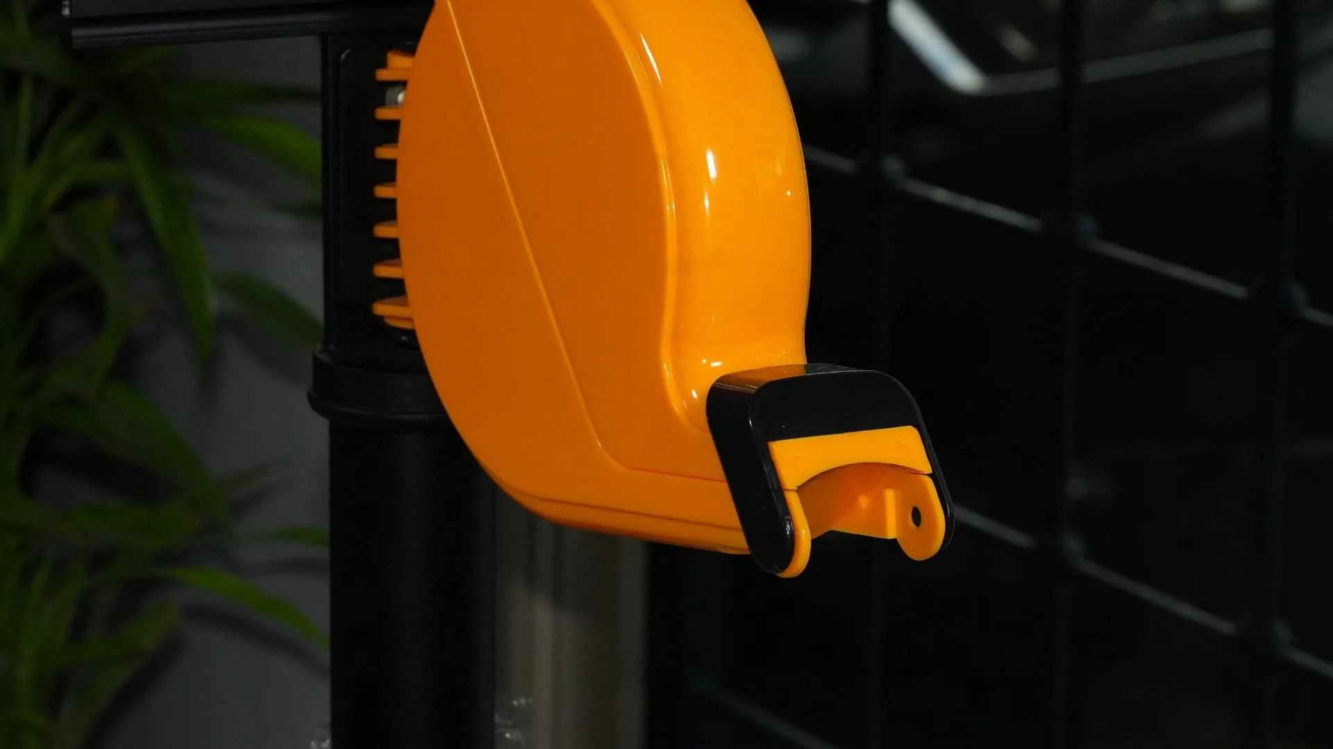Dispensador naranja de tickets del kit toma turnos, visto de cerca.