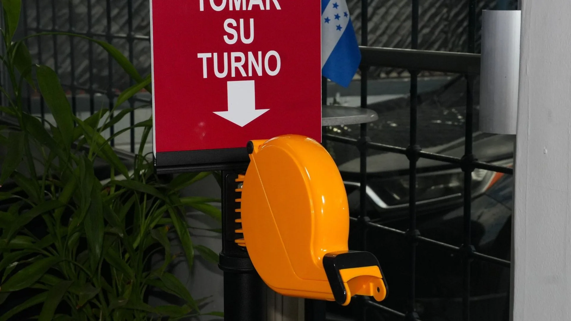 Letrero y dispensador del kit toma turnos montados en su poste.