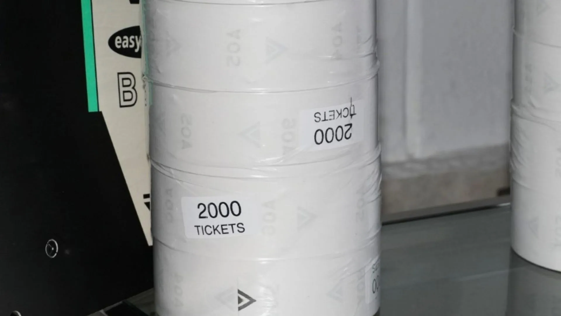Rollos de 2000 tickets del kit toma turnos EASYTURN, junto a su caja.
