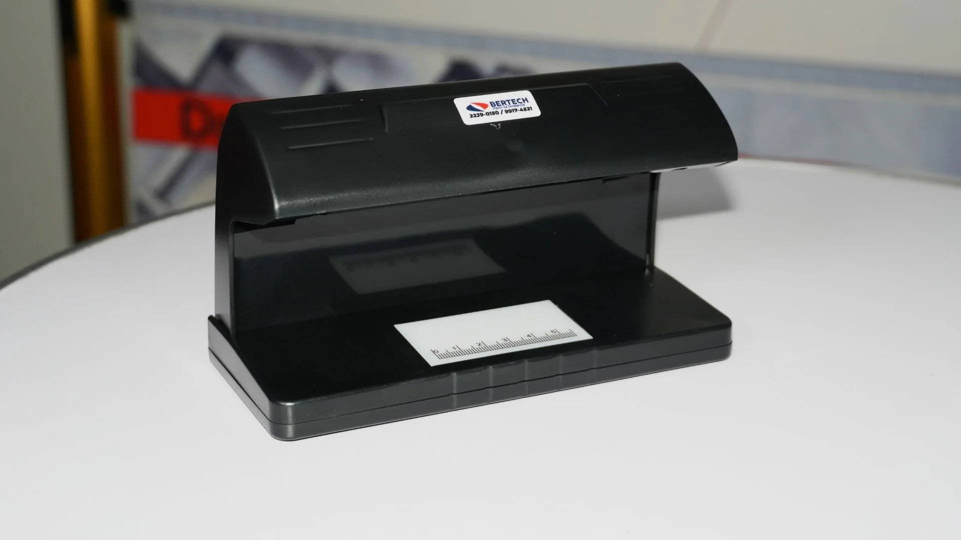 Lámpara UV para detectar billetes falsos de cuerpo entero, con la calcomanía de Bertech y la regla en la base.