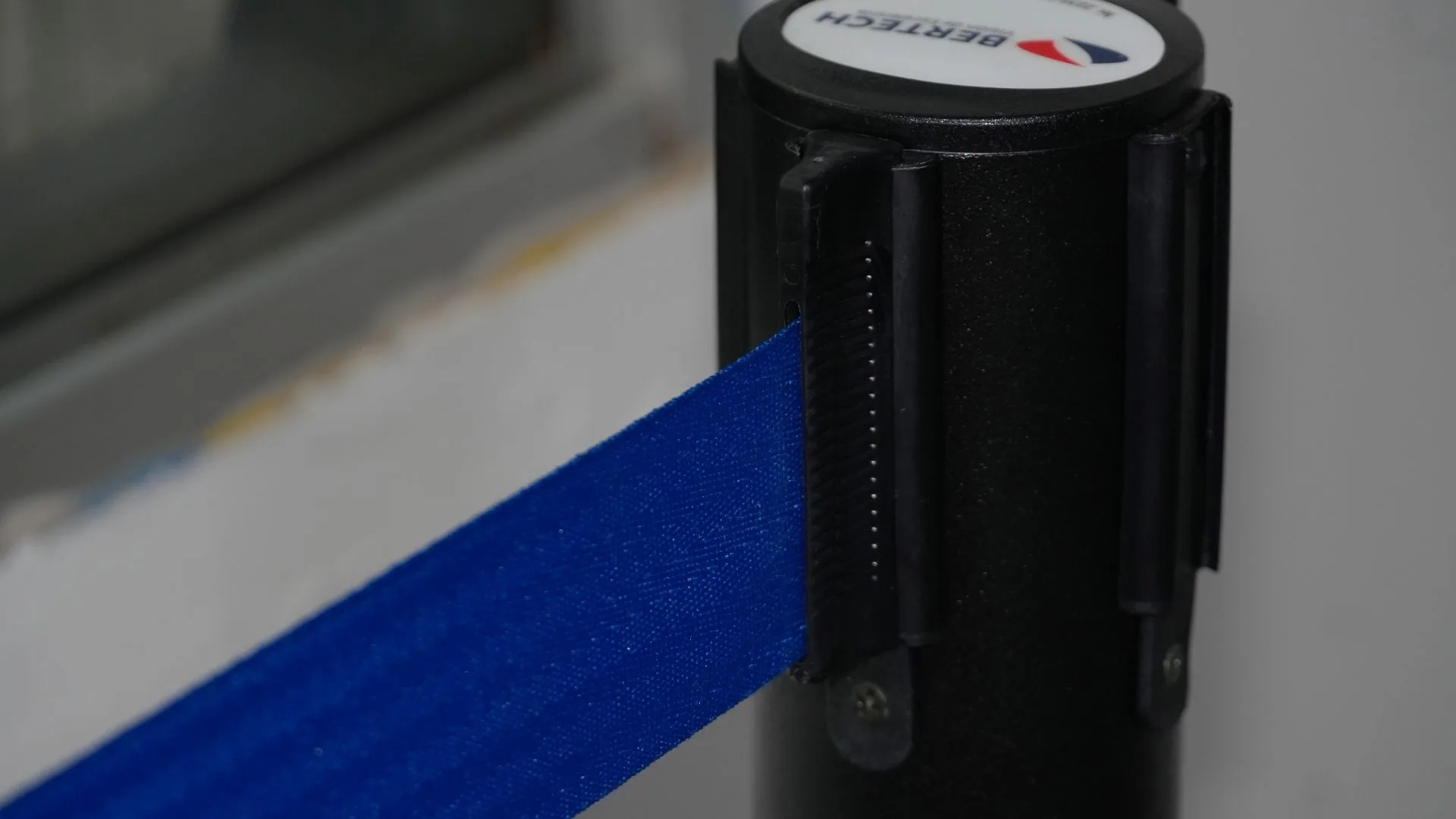 Cinta retráctil azul saliendo del cabezal de un poste de fila sencillo.