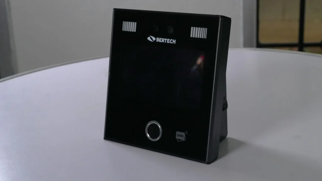 Reloj biométrico facial con el logotipo de Bertech, de frente, con su pantalla, sus cámaras y el lector de huella.