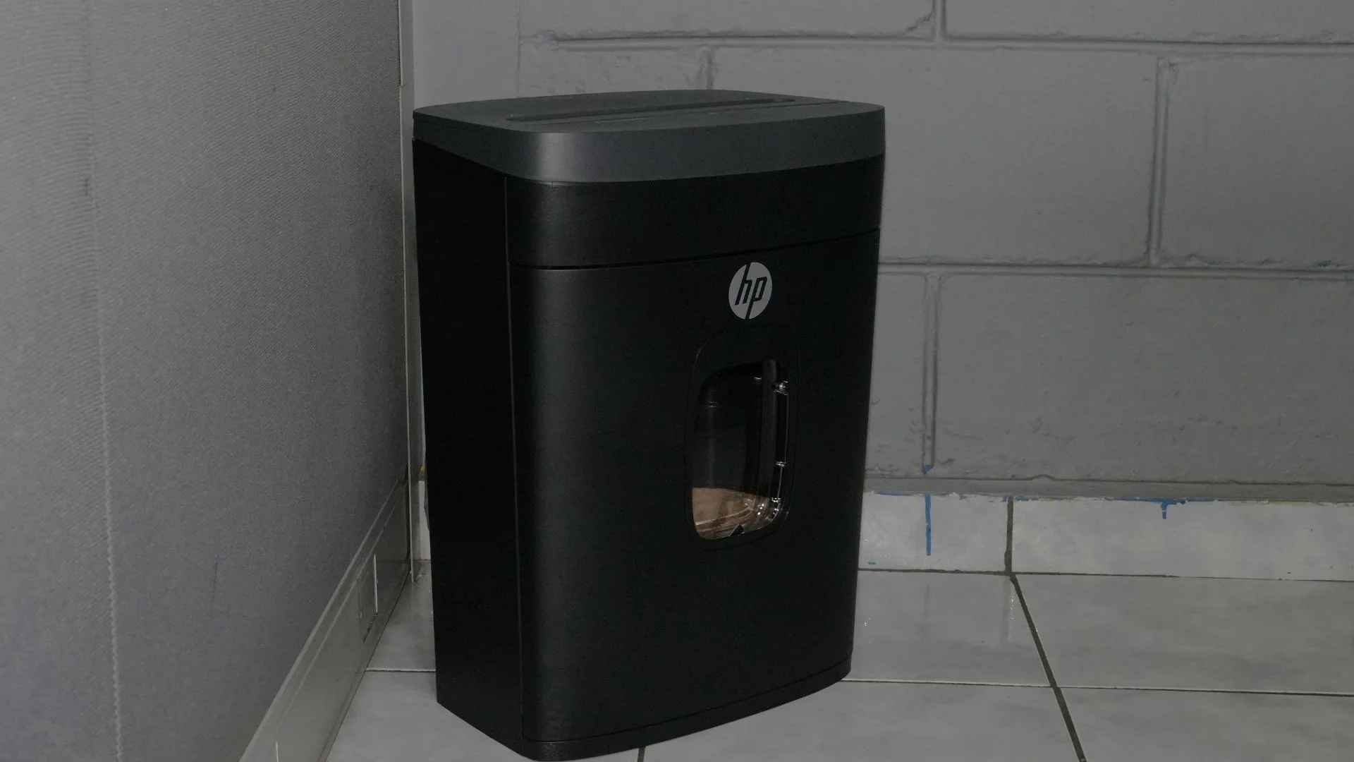 Trituradora de papel HP MC145 de cuerpo entero, en una esquina.